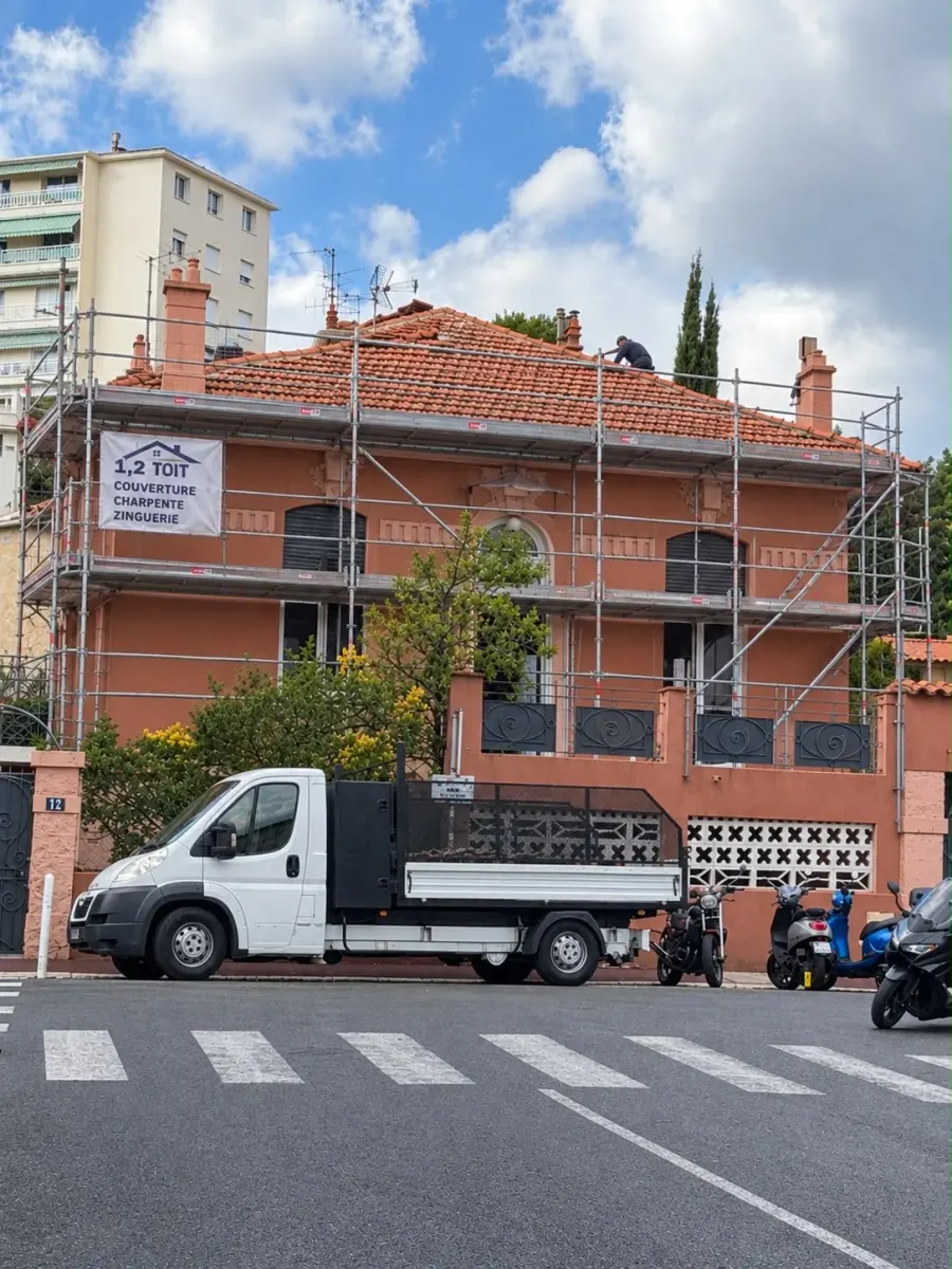 Échafaudage et camion 1,2,TOITS devant une maison en réfection de toiture, couvreur sur le versant